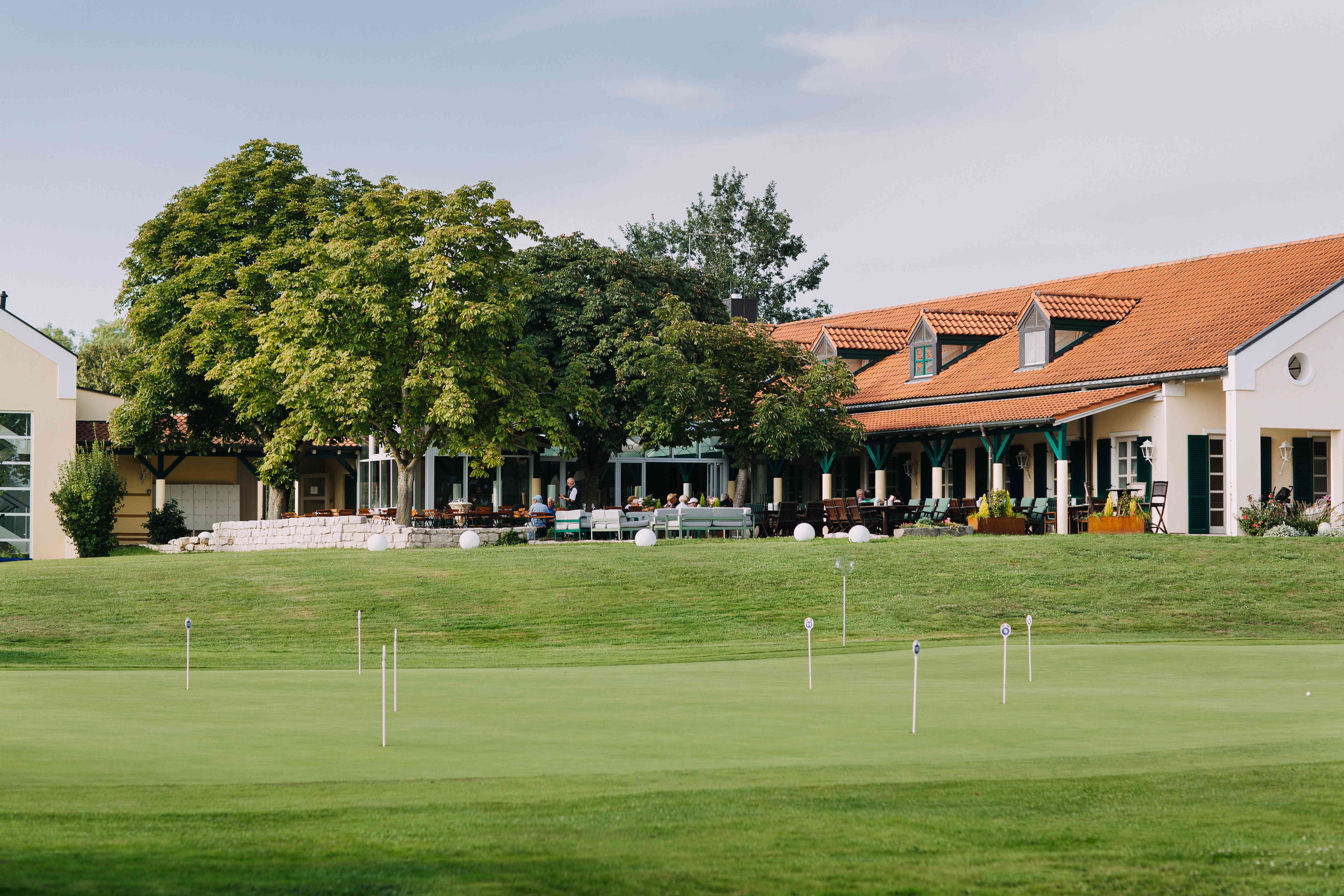 Die Restaurantterrasse & Hotel Gutshof Sagmühle und der davorliegende Golfplatz